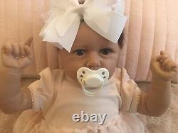 Lovely reborn baby girl doll. Hand rooted dark brown hair. 21 ins