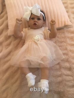 Lovely reborn baby girl doll. Hand rooted dark brown hair. 21 ins