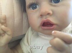 Lovely reborn baby girl doll. Hand rooted dark brown hair. 21 ins